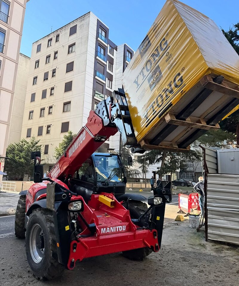 Manitou telehandler çatal ataşmanıyla yük kaldırırken